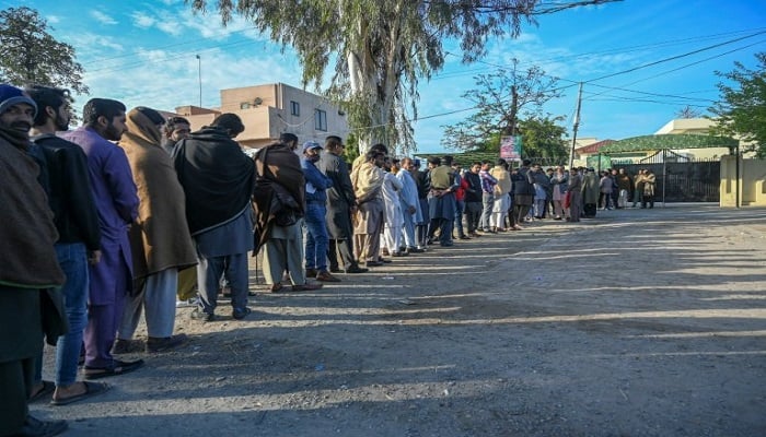 People queue outside the passport office in Gujrat district. — AFP