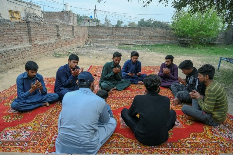 Mourners pray for Muhammad Nadeem, near his house in Gujrat district. — AFP