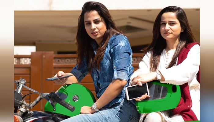 Two women pose for the camera while sitting on their bikes. — Supplied