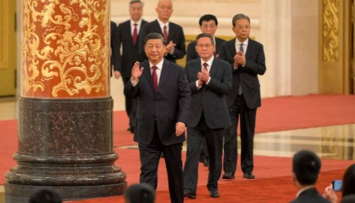 China´s President Xi Jinping (front) walks with members of the Chinese Communist Party´s new Politburo Standing Committee, the nation´s top decision-making body, as they meet the media in the Great Hall of the People in Beijing on October 23, 2022.— AFP