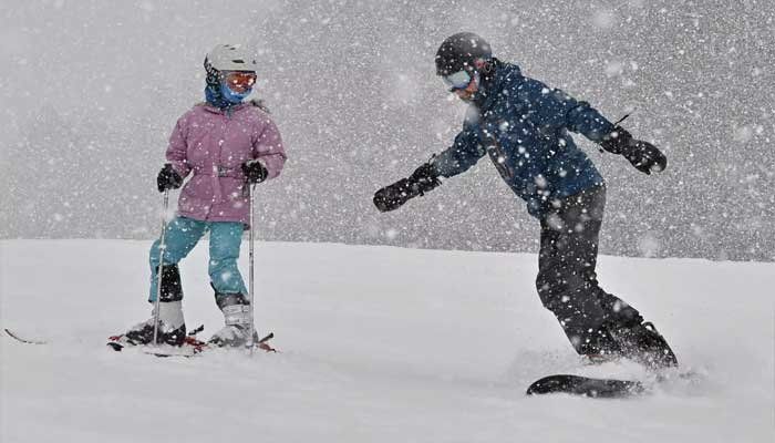 Skiers skateboard in snow at a resort in Fukushima. — AFP/File