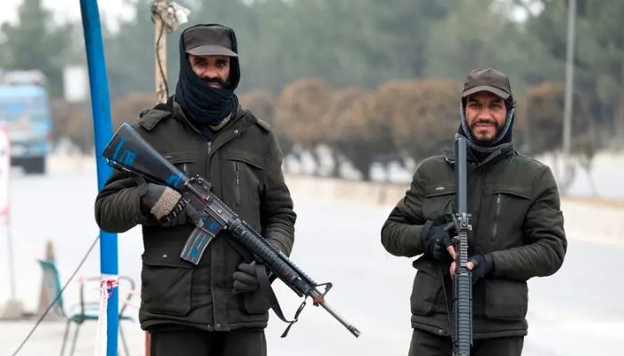 Taliban güvenlik personeli, 10 Ocak 2023'te Kabil'de bir cadde boyunca bir kontrol noktasında nöbet tutuyor.— AFP