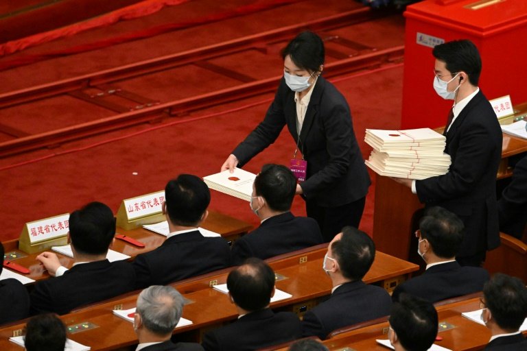 Personel üyeleri, 10 Mart 2023'te Pekin'deki Büyük Halk Salonunda Ulusal Halk Kongresi'nin (NPC) üçüncü genel kurulunda delegelere oy pusulaları dağıttı. — AFP