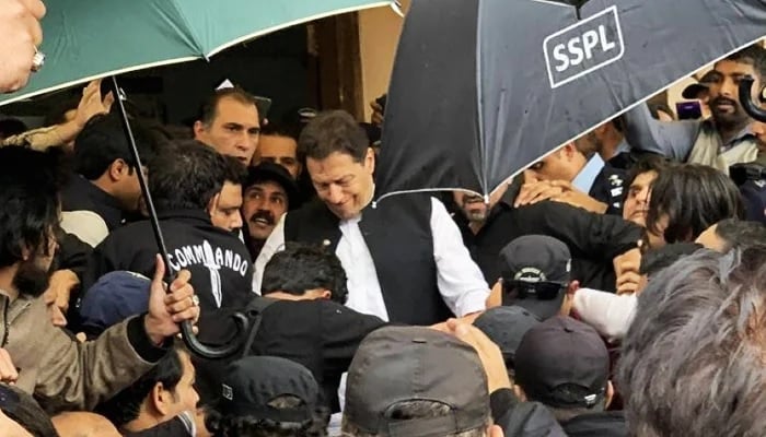 Eski başbakan Imran Khan (ortada), 28 Şubat 2023'te İslamabad'daki bir mahkemeye çıktıktan sonra ayrılıyor. — AFP