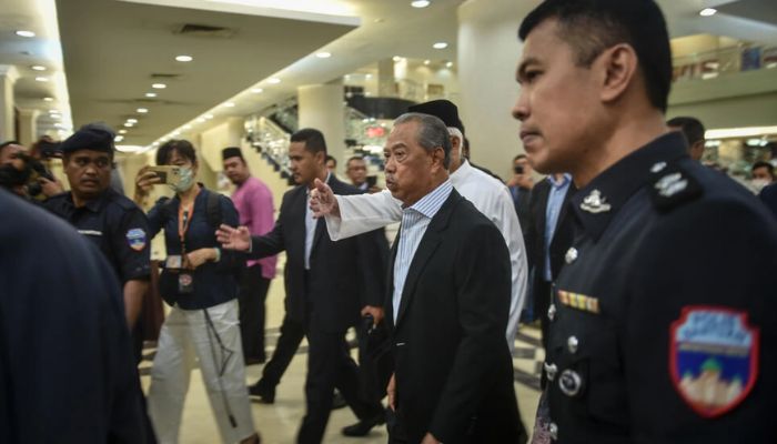 Malaysias former prime minster Muhyiddin Yassin (C) has been charged with accepting bribes and money laundering.— AFP