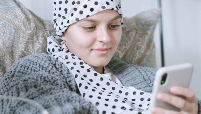 A woman on a hospital bed using her cellphone. — Pexels