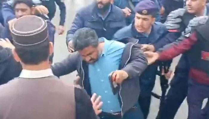 Police manhandle journalist Saqib Bashir at the judicial complex in Islamabad, on February 28, 2023, in this still taken from a video. — Photo by author