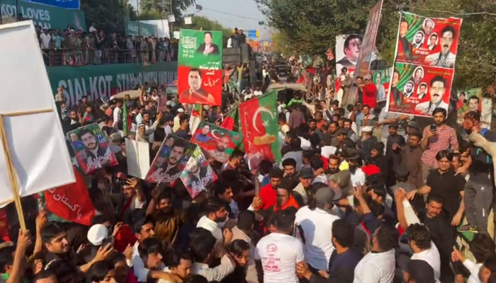 PTI workers in front of PTI Chairman Imran Khans vehicle at Zaman Park in Lahore, on March 13, 2023, in this still taken from a video. — Twitter/PTI