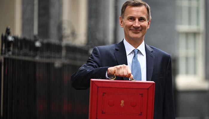 Britains Chancellor of the Exchequer Jeremy Hunt poses with the red Budget Box as he leaves 11 Downing Street in central London on March 15, 2023, to present the government´s annual budget to Parliament. — AFP