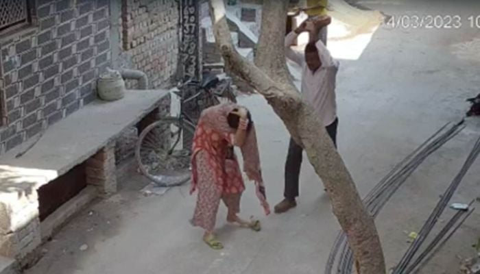 Video screengrab shows man hitting his daughter-in-law with a brick.— NDTV