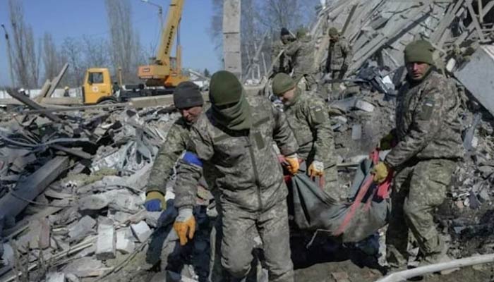 Ukrainian soldiers carried a comrades body out of debris Saturday at a military school hit by Russian rockets in Mykolaiv. — AFP/File
