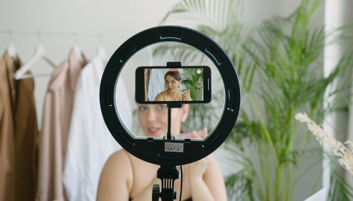 A woman video recording herself using a cellphone camera. Pexels