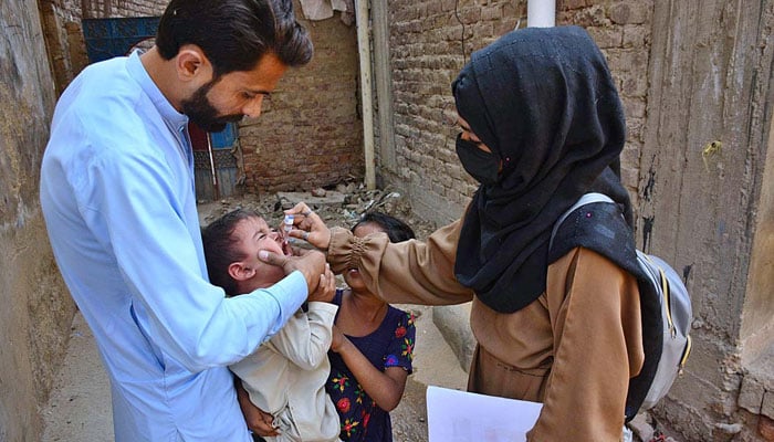 A health worker administers polio vaccine to a child during Polio Free Pakistan campaign in Latifabad. — APP/File