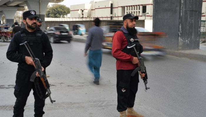 Policemen stand guard along a street in Peshawar on February 1, 2023, days after a mosque suicide blast inside a police headquarters. — AFP