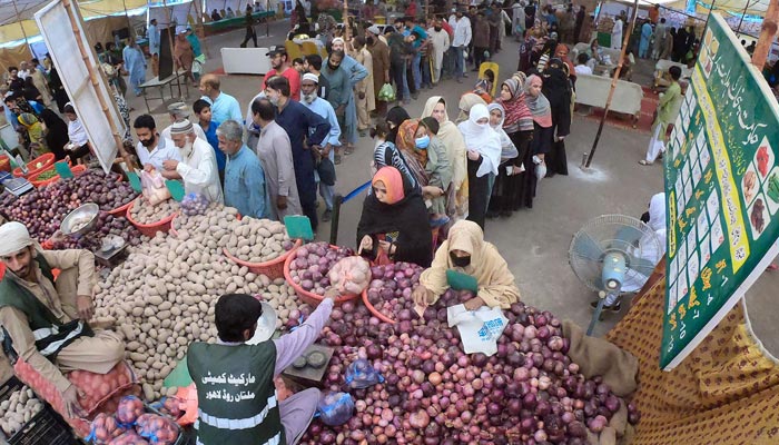 People are standing in long queues to buy vegetables from a vender at Ramadan Sasta Bazaar in the Islampura area in Lahore on April 27, 2022. — Online/File
