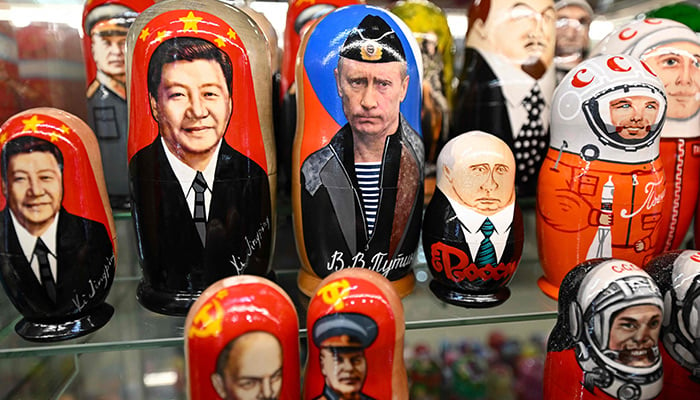 This picture taken on March 20, 2023 shows traditional Russian wooden nesting dolls, called Matryoshka dolls, depicting Chinese President Xi Jinping and Russian President Vladimir Putin at a gift shop in central Moscow. — AFP