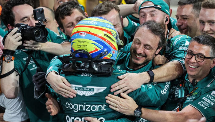 Fernando Alonso is embraced by his pit crew after finishing third before stewards ruled one of them had got too close during the race, only to later withdraw the charge. AFP