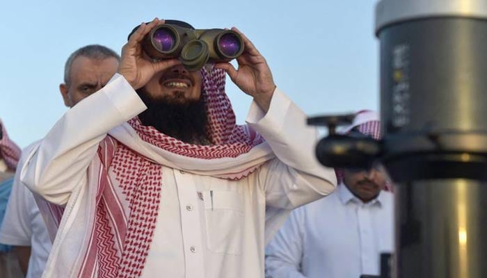 A man uses binoculars to spot the first crescent moon, marking the start of Ramadan, in the southwestern Saudi city of Taif last April.  — AFP