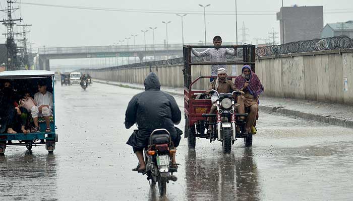 A motorcyclist on the way to home during a heavy spell of monsoon rain in Karachi on July 14, 2022. — APP