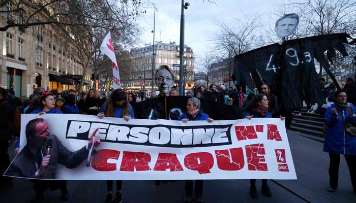 Protesters hold a banner and placards at Place de la Republique during a demonstration in Paris on March 21, 2023. — AFP