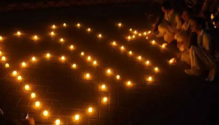 Girls light candles in front of Sindh Assembly on the eve of Earth Hour in Karachi. AFP/File