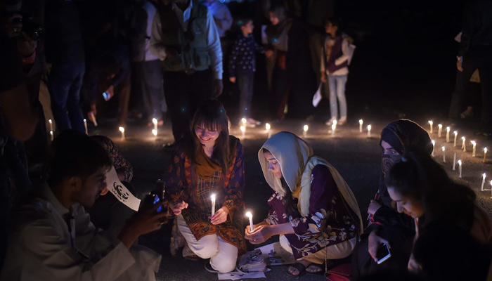 People light candles in front of Parliament House during Earth Hour in Islamabad, on March 31, 2019. ─ AFP/File