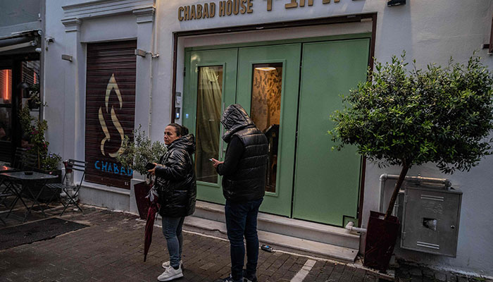 Members of the public stand in front of a Jewish restaurant in central Athens, on March 28, 2023. Greek police sources told AFP on March 28, 2023, they had arrested two young Pakistanis of Iranian origin who were planning anti-Semitic attacks in central Athens. The source said that the men had targeted a building which houses a synagogue and a Jewish restaurant.—AFP