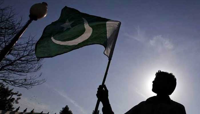 A representational image of the a mans silhouette waving Pakistani flag. — Twitter/File