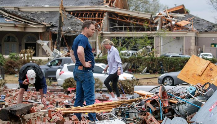 In this file photo taken on March 31, 2023, Kris French (C) and his family search through rubble for a video recorder they think captured a direct tornado strike to their business, Champs Car Wash, after a tornado damaged hundreds of homes and buildings in Little Rock, Arkansas.— AFP