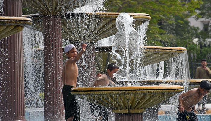 Children are bathing in a fountain at Arts Council Chowrangi during hot weather in Karachi. — Online
