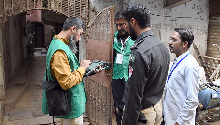 An official from the Pakistan Bureau of Statistics uses a digital device to collect information from a resident during the first-ever digital national census in Karachi on March 3, 2023. — Online