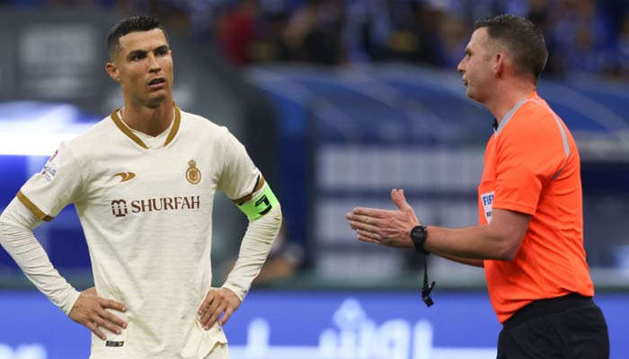 Ronaldo (Solda), 18 Nisan 2023'te başkent Riyad'daki Prince Faisal Bin Fahd stadyumunda Al-Hilal ile Al-Nassr arasında oynanan maçta İngiliz hakem Michael Oliver'ı dinliyor. — AFP