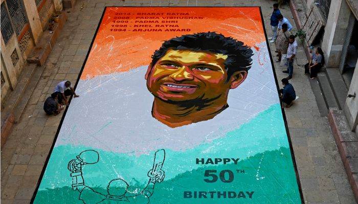 İnsanlar Hintli eski uluslararası kriket oyuncusu Sachin Tendulkar'ın 24 Nisan 2023'te Mumbai'de 50. doğum günü vesilesiyle yaptığı bir tablonun yanında duruyor.— AFP