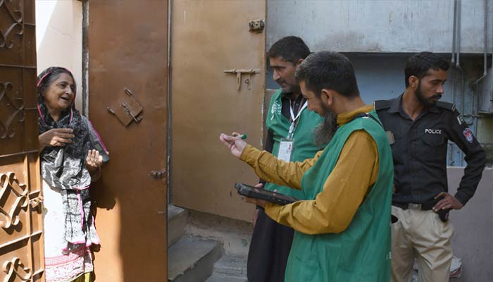 A Pakistan Bureau of Statistics official uses a digital device to collect information from a resident during door-to-door data collection at the first-ever digital national census in Karachi on March 28, 2023. — ONLINE