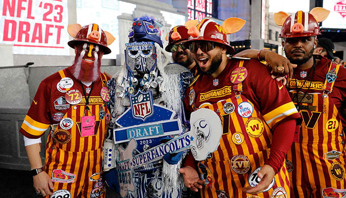 Washington Commanders taraftarları, 27 Nisan 2023'te Kansas City, Missouri'de Union Station'da 2023 NFL Draftının ilk turundan önce bir Indianapolis Colts hayranıyla poz veriyor.  AFP
