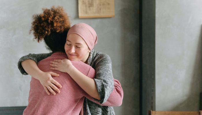 Image shows two women hugging each other.— Pexels