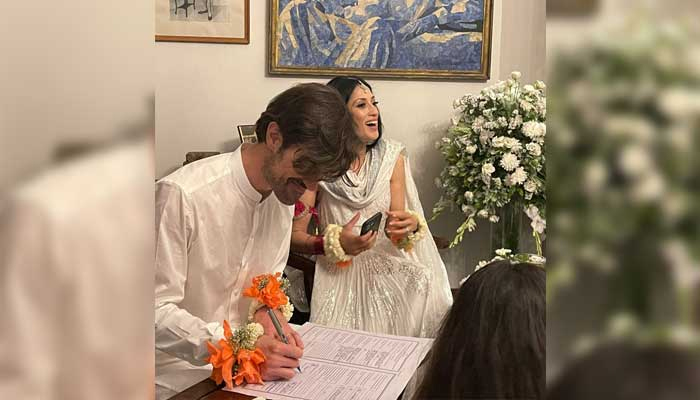 Gibran (Graham) signs the marriage contract while Fatima Bhutto smiles in the background. — Twitter/@fbhutto