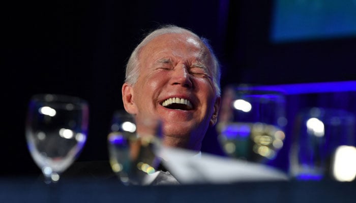 ABD Başkanı Joe Biden, Washington DC'deki Washington Hilton Oteli'nde düzenlenen Beyaz Saray Muhabirleri Derneği galasında gülüyor.  — AFP