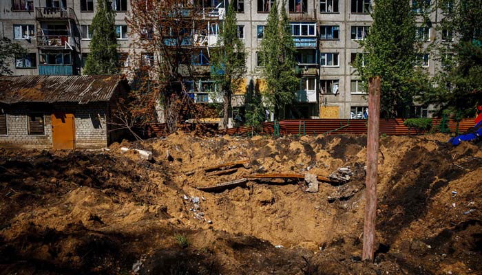 3 مئی 2023 کو یوکرین کے چاسیو یار میں میزائل حملے کے بعد تباہ شدہ رہائشی عمارت اور گڑھا۔ – اے ایف پی