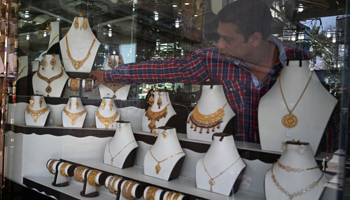 A shopkeeper sets gold jewellery at his store in Rawalpindi in this undated file photo. — AFP