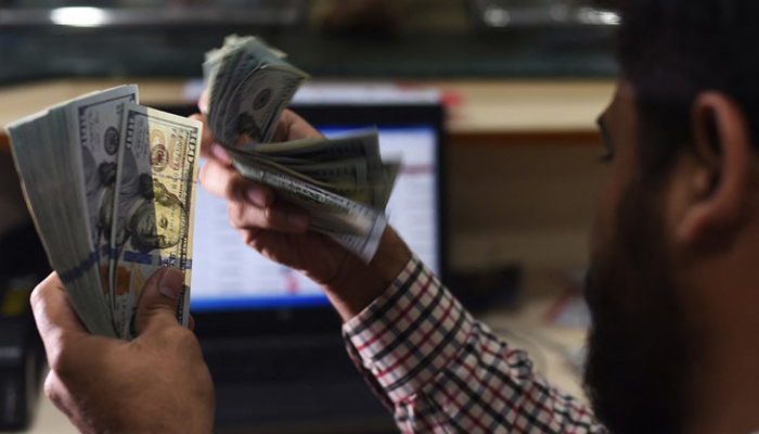 A dealer counts US currency notes at an exchange in Karachi on October 9, 2018. — AFP/File