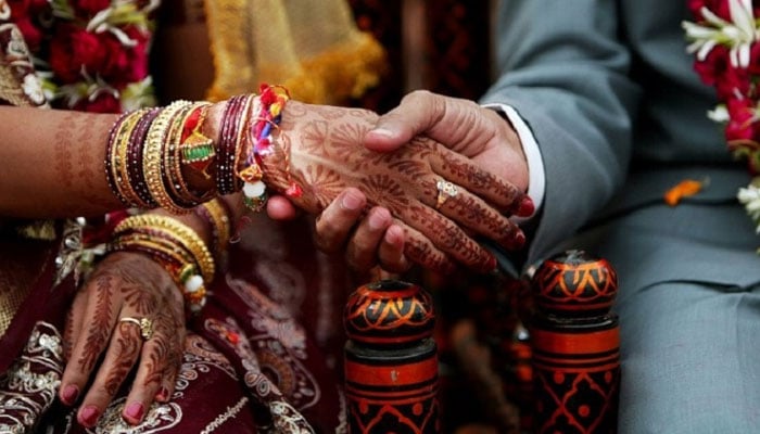 L'immagine mostra una coppia che si sposa.  — AFP/File