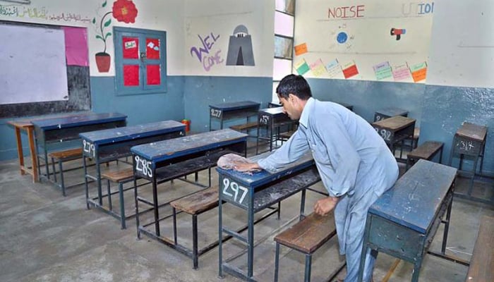 A worker cleans benches and desks at a school in Rawalpindi on September 14, 2020. — APP/File
