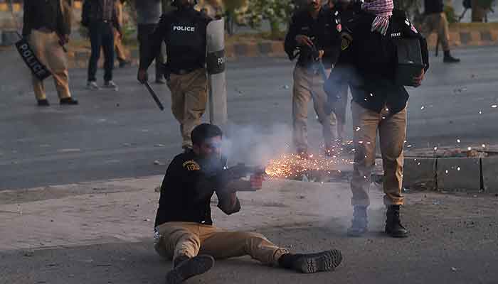 Police fire tear gas shells towards Pakistan Tehreek-e-Insaf (PTI) party activists and supporters of former Pakistan´s Prime Minister Imran during a protest against the arrest of their leader, in Karachi on May 9, 2023. — AFP