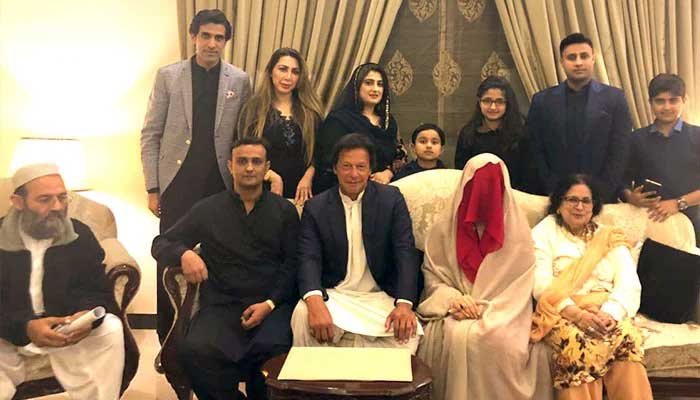 Imran Khan (ortada), Nikkah'larından sonra Bushra Bibi ile oturuyor.  — Twitter/@PTIOresmi