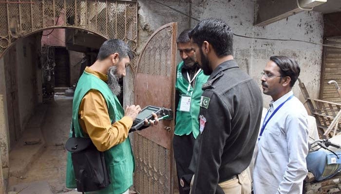 Bir Pakistan İstatistik Bürosu yetkilisi, 28 Mart 2023'te Karaçi'de yapılan ilk dijital ulusal nüfus sayımında kapı kapı dolaşarak veri toplarken bir sakinden bilgi toplamak için dijital bir cihaz kullanıyor. — ÇEVRİMİÇİ