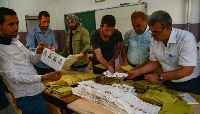 Diyarbakır'da 14 Mayıs 2023'te yapılan cumhurbaşkanlığı ve milletvekilliği seçimlerinde sandıklar kapandıktan sonra seçim görevlileri bir sandıkta oy pusulalarını sayıyor. — AFP