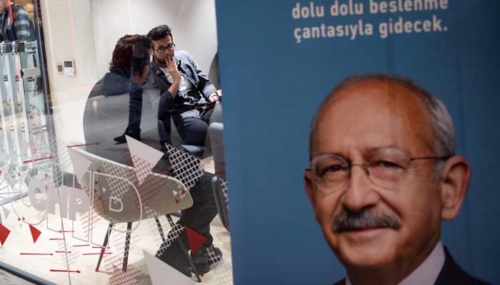 CHP'liler, 14 Mayıs 2023'te Türkiye'de cumhurbaşkanlığı ve milletvekilliği ilk tur seçimlerinde sandıkların kapanmasının ardından İstanbul'daki CHP binasında televizyon izliyor.  — AFP