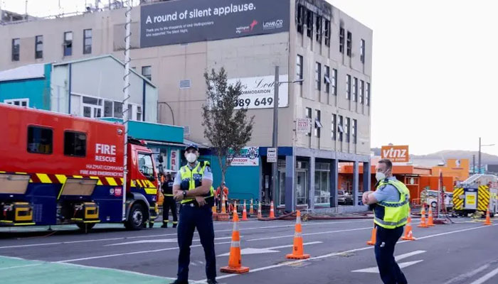 Polis, 16 Mayıs 2023'te Wellington'daki Loafers Lodge pansiyon binasında çıkan yangında nöbet tutuyor. — AFP