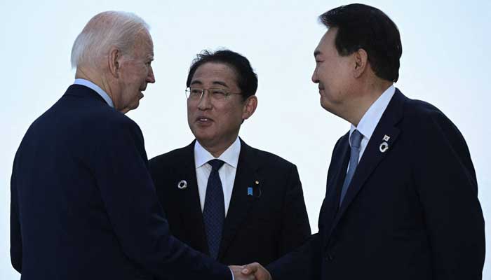 US President Joe Biden (left), Japanese Prime Minister Fumio Kishida and South Korean President Yoon Suk-Yeol gather for a trilateral meeting in Hiroshima on May 21, 2023. — AFP